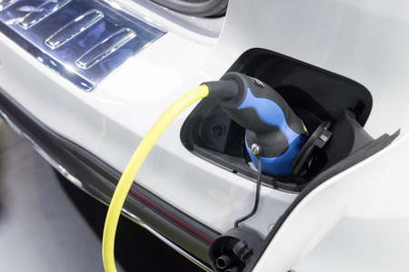 The electric car charger plugged in to the socket.The modern electric car charging the battery