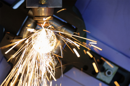 The CNC laser cut machine while cutting the steel tube  with the sparking light.The hi-precision tube cutting process by laser cutの写真素材
