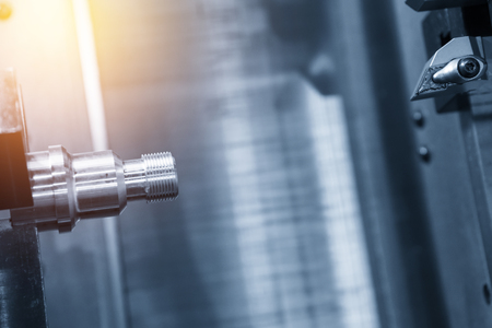 Abstract scene of CNC lathe machine (Turning machine) while cutting the screw thread with glowing edge lighting effectの写真素材
