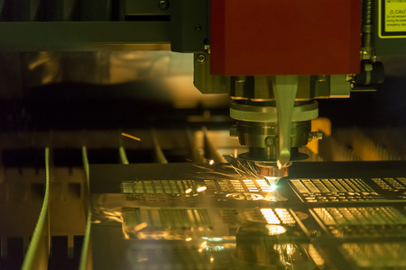 The fiber  laser cutting machine  cutting the sheet metal plate with the sparking...