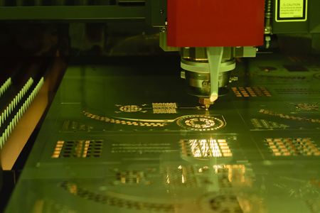 The fiber  laser cutting machine  cutting the sheet metal plate with the sparking light.Hi-technology manufacturing concept.の写真素材