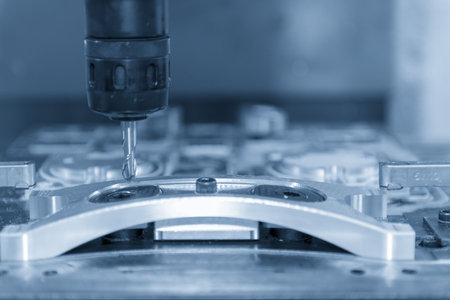The CNC machine cutting the automobile part in the light blue scene.Automobile parts manufacturing process.の写真素材