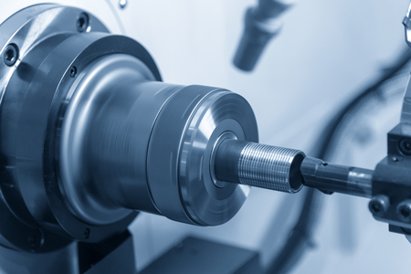 The CNC lathe machine cutting the thread at the end of the pipe.The water pipe manufacturing process.の写真素材