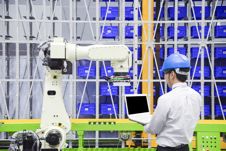 The programmer engineer control the robot for logistic warehouse.The hi-technology logistic industrial.の写真素材
