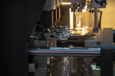 The  plastic bottles manufacturing process at the drinking factory in the light blue scene. Drinking water manufacturing process.の写真素材