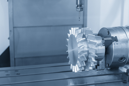 The 3-axis CNC milling machine or machining center attach the rotation axis cutting the turbine part  with the solid ball endmill tool in the light blue scene.The Hi-Technology manufacturing process.の写真素材
