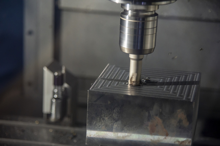 The CNC milling machine cutting the mold part in roughing   process with the index-able radius endmill tool.Hi-technology manufacturing process.の写真素材
