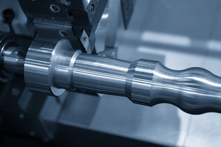 The CNC lathe machine cutting   the  at the steel shaft in the light blue scene .Hi-technology...