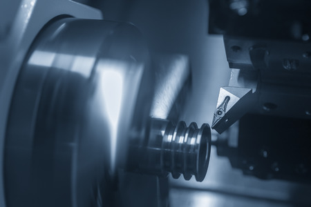 The CNC lathe or turning machine cutting  the slot  at the metal part.Hi-technology manufacturing process.の写真素材