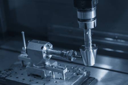 The EDM machine making the spiral groove on the cone shape. The rotary EDM process with special...