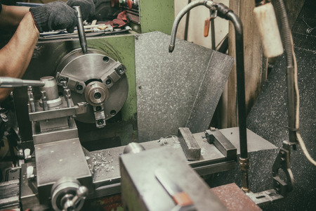 The skill operator working with lathe machine in vintage scene.The lathe machine cutting the metal shaft with the cutting tool.の写真素材