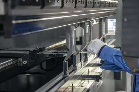 The technician operator use hydraulic bending machine. The sheet metal manufacturing process.の写真素材