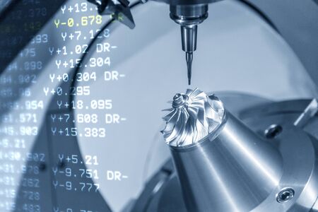 The abstract scene of 5-axis CNC machine and the NC code-data background. The automotive parts manufacturing process by 5-axis machining center.の写真素材
