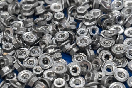 The pile of the special nuts in the container box. The nuts and bolts manufacturing process.