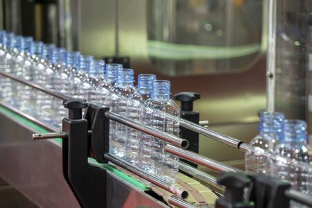 The PET bottles on the conveyor belt for filling process in the drinking water factory. The drinking water factory production process by automatic filling machine in the plant.の写真素材