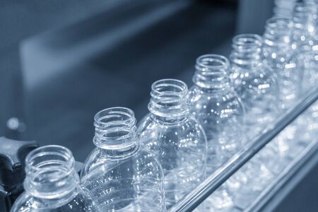 The PET bottles on the conveyor belt for filling process in the drinking water factory. The drinking water factory production process by automatic filling machine in the plant.の写真素材