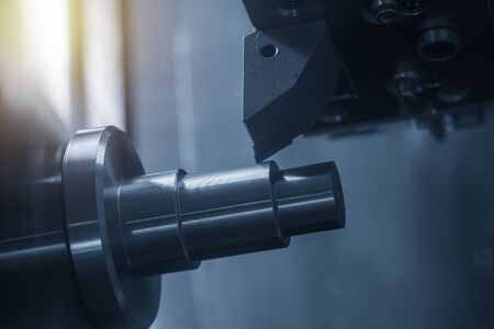 The CNC lathe machine in metal working process cutting the metal shaft parts with in the light blue scene. The hi-technology metal working processing by CNC turning machine .の写真素材