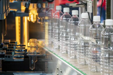 The abstract scene of tube preform shape of bottles preheat process and the plastic bottle in the conveyor belt. The PET bottle manufacturing processing.の写真素材