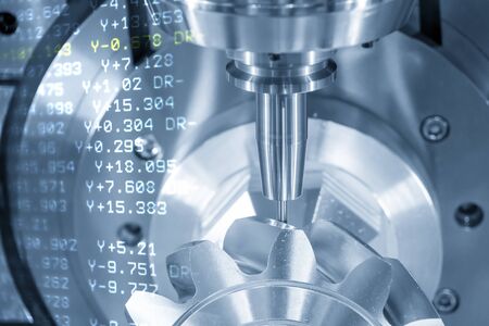 The abstract scene of 5 axis CNC milling machine cutting the metal gear parts with solid ball endmill tools. The hi-technology automotive part manufacturing process by 5 axis machining center.の写真素材