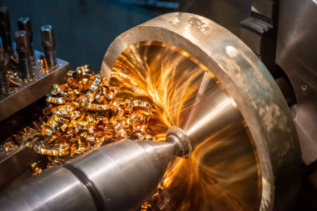 Close-up scene of turning chip of brass material .The operation of lathe machine cutting the brass  shaft parts with the cutting tools.の写真素材