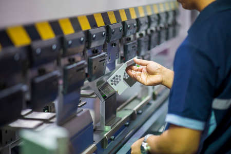 The operation of hydraulic bending machine with technician.  The  sheet metal manufacturing process...
