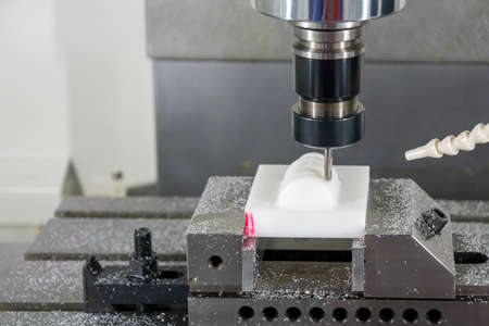 The  CNC  milling machine cutting  the engineering plastic parts by solid endmill tool. The hi-precision non-metal part manufacturing concept by machining center.の写真素材