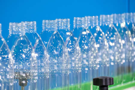 The PET bottles  on the conveyor belt for filling process in the drinking water factory. The...