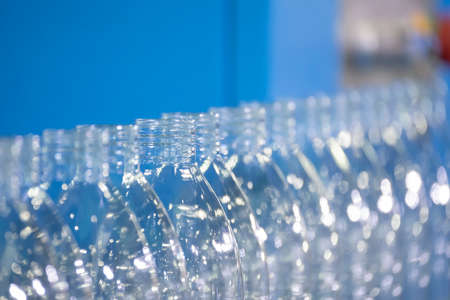 The PET bottles  on the conveyor belt for filling process in the drinking water factory. The hi-technology of plastic bottle manufacturing process.の写真素材