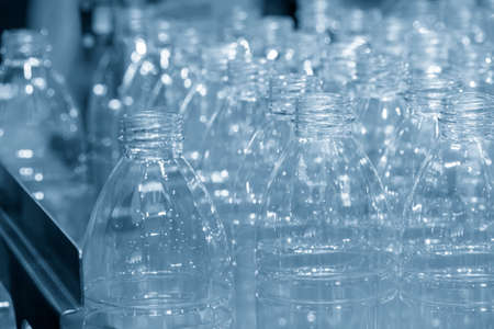 The PET bottles  on the conveyor belt for filling process in the drinking water factory. The...