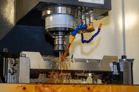 The CNC milling machine cutting the  mold parts with oil coolant method. The mold and die...