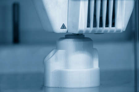 Close-up scene of 3D printer operation in the light blue scene. The rapid prototype manufacturing...