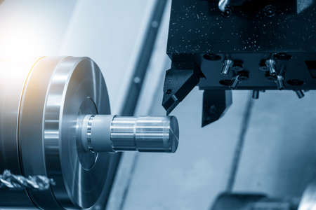 The  CNC lathe machine cutting the metal shaft parts. The hi-technology metal working processing by CNC turning machine .の写真素材
