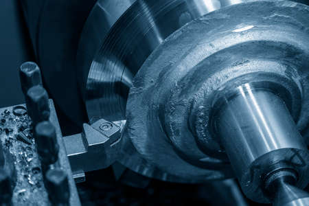 The lathe machine operation by rough cutting brass material parts by cutting tools. The metalworking process by turning machine.の写真素材