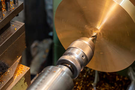 The lathe machine drilling the brass plate parts. The hi-technology metal working processing by CNC turning machine .の写真素材