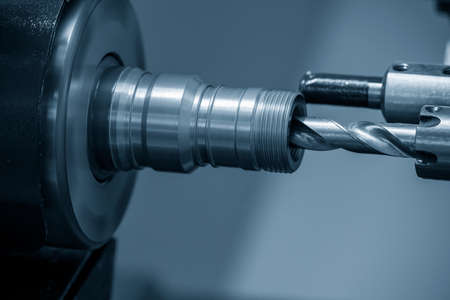 The  CNC lathe machine bore cutting the brass pipe connector parts. The hi-technology metal working processing by CNC turning machine .の写真素材
