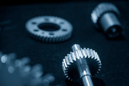 The spare part of  metal pinion gear with shaft.  The abstract scene of gear part of automotive...