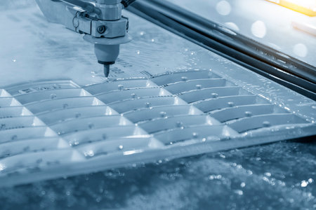 Close-up scene of multi-axis abrasive waterjet cutting machine cutting the aluminum plate. The high...