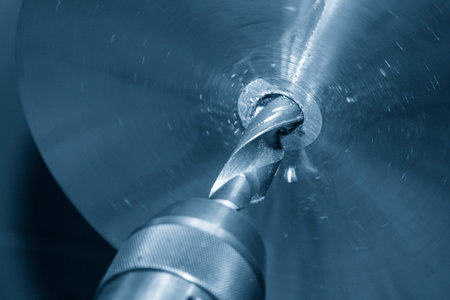 The lathe machine hole cutting the metal parts by drill tools. The metalworking process by turning machine.の写真素材