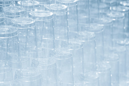 The pile of plastic cups in the light blue scene. The plastic products from injection process.の写真素材