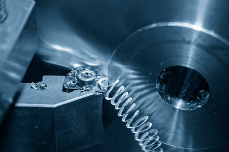 Close-up the lathe machine finish cutting the brass disk parts by lathe tools. The metalworking process by turning machine.の写真素材