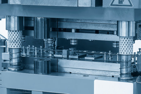 Closeup scene of the progressive die operation in the light blue scene. The metalworking equipment...