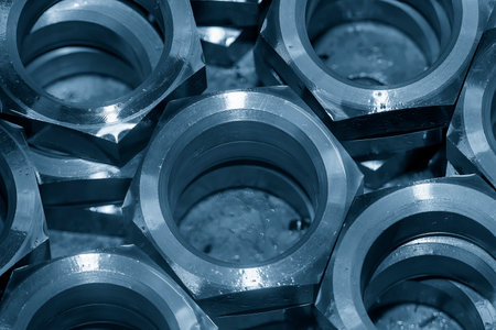The pile of large size hexagon nut parts in the light blue scene. The mechanical  parts manufacturing process.の写真素材