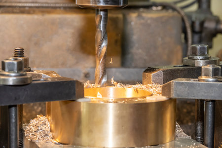 The drilling process on NC milling machine with brass material. The metal working concept on the...