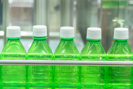 The  empty  green drinking  bottles  on the conveyor belt for filling process. The hi-technology of drinking water manufacturing process.の写真素材