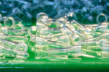 The raw material for plastic bottle manufacturing process. Close up scene of group of preform shape...