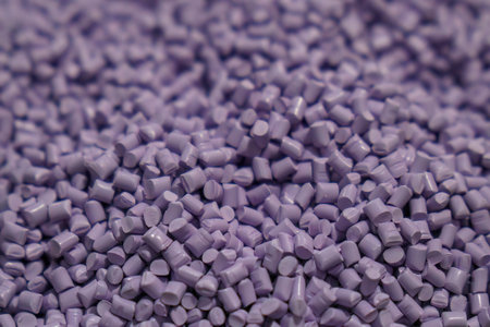 The pile of violet pellets materials for plastic injection process. The raw material from...