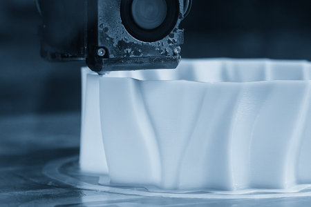 Close up scene the 3D model operation by additive manufacturing by 3D printer machine in the blue scene tone. The high technology manufacturing process by rapid prototype method.の写真素材