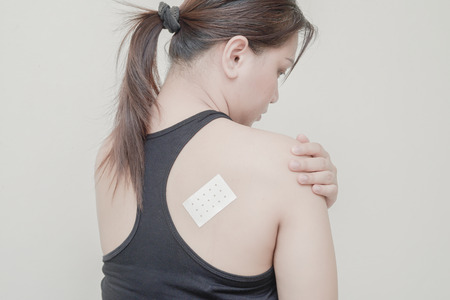 Women Muscular back pain and sticking plaster.の写真素材