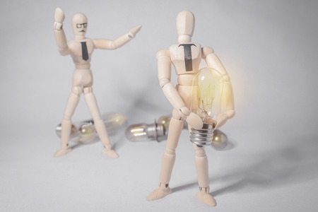 Wooden puppets and light bulbs Creative conceptの写真素材