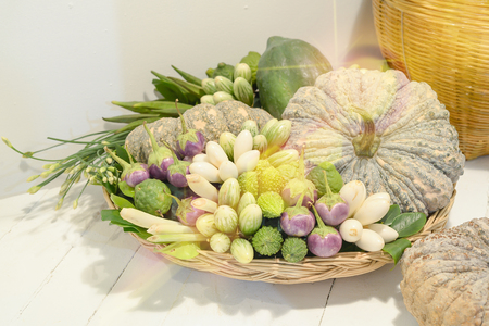 Many Asian vegetables in a basket placed on a flat surface.の写真素材